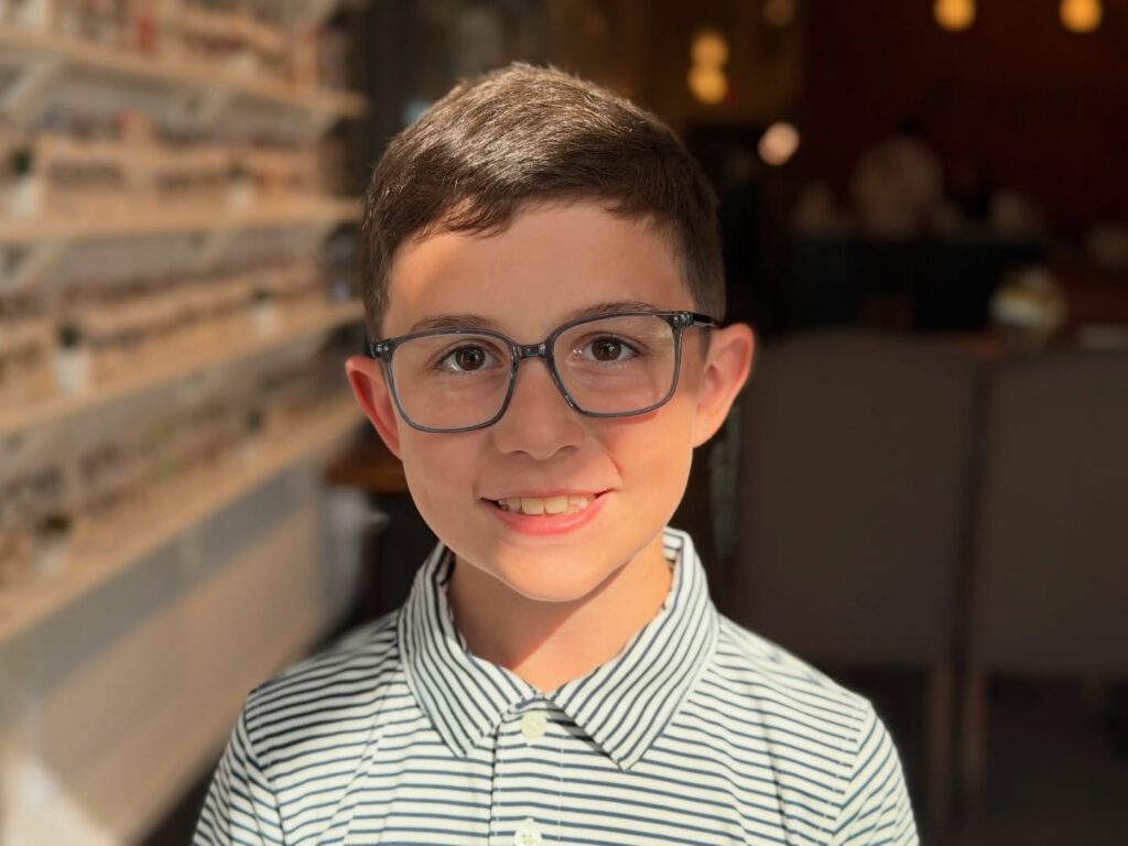 A boy smiling with glasses